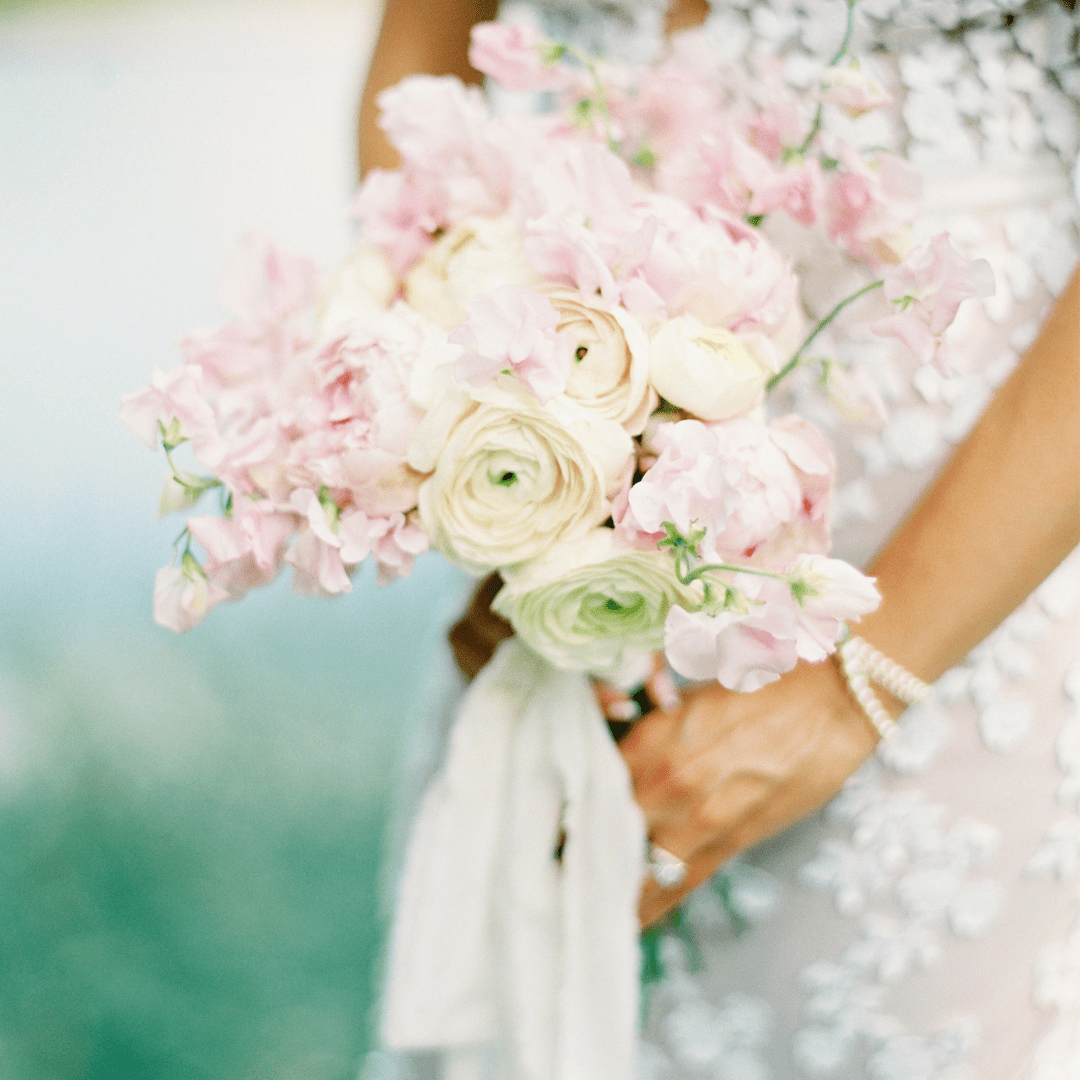 Elegant and luxe pink and white bridal bouquet featuring Ranunculus and Sweetpeas