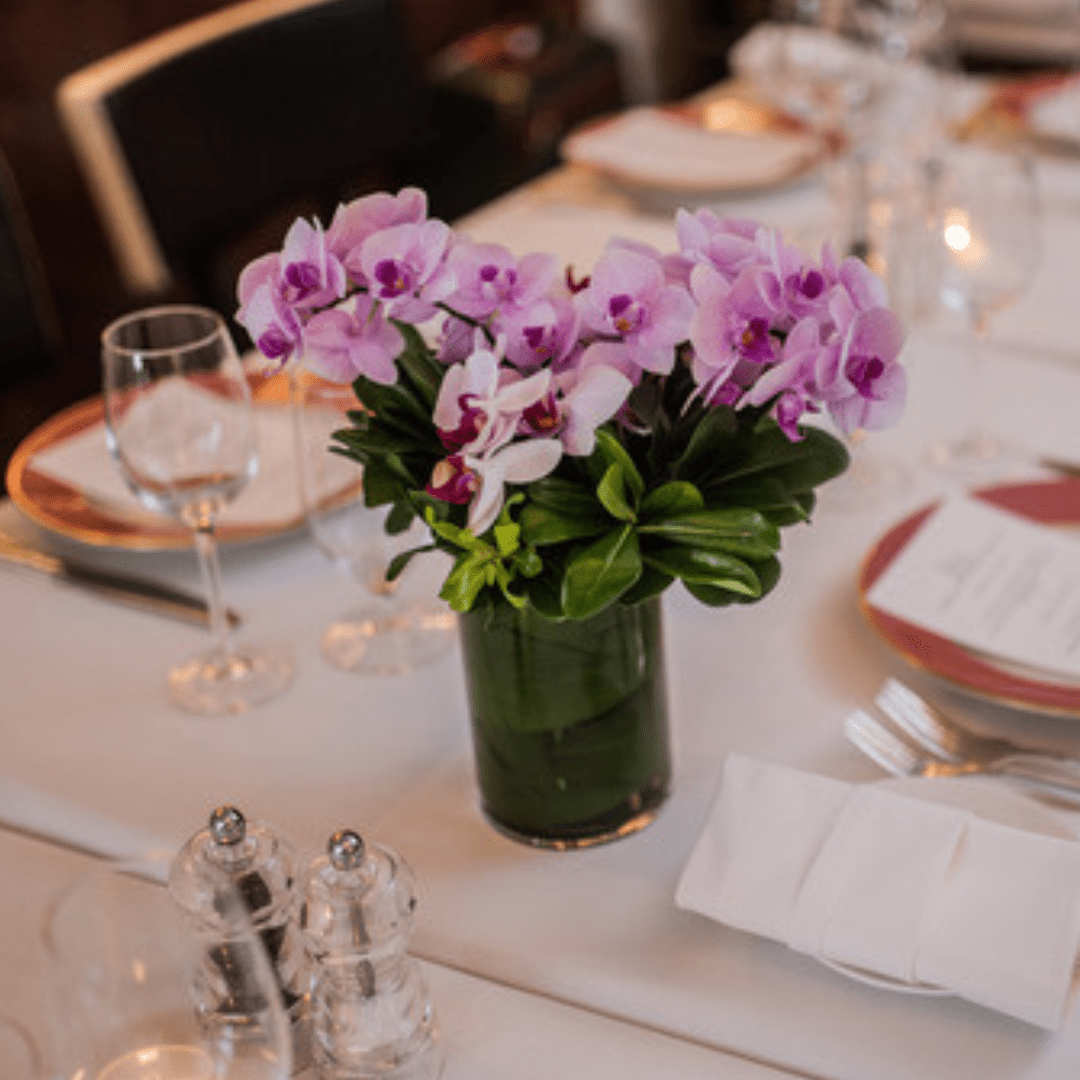 Small centerpiece featuring pink Orchids and greenery