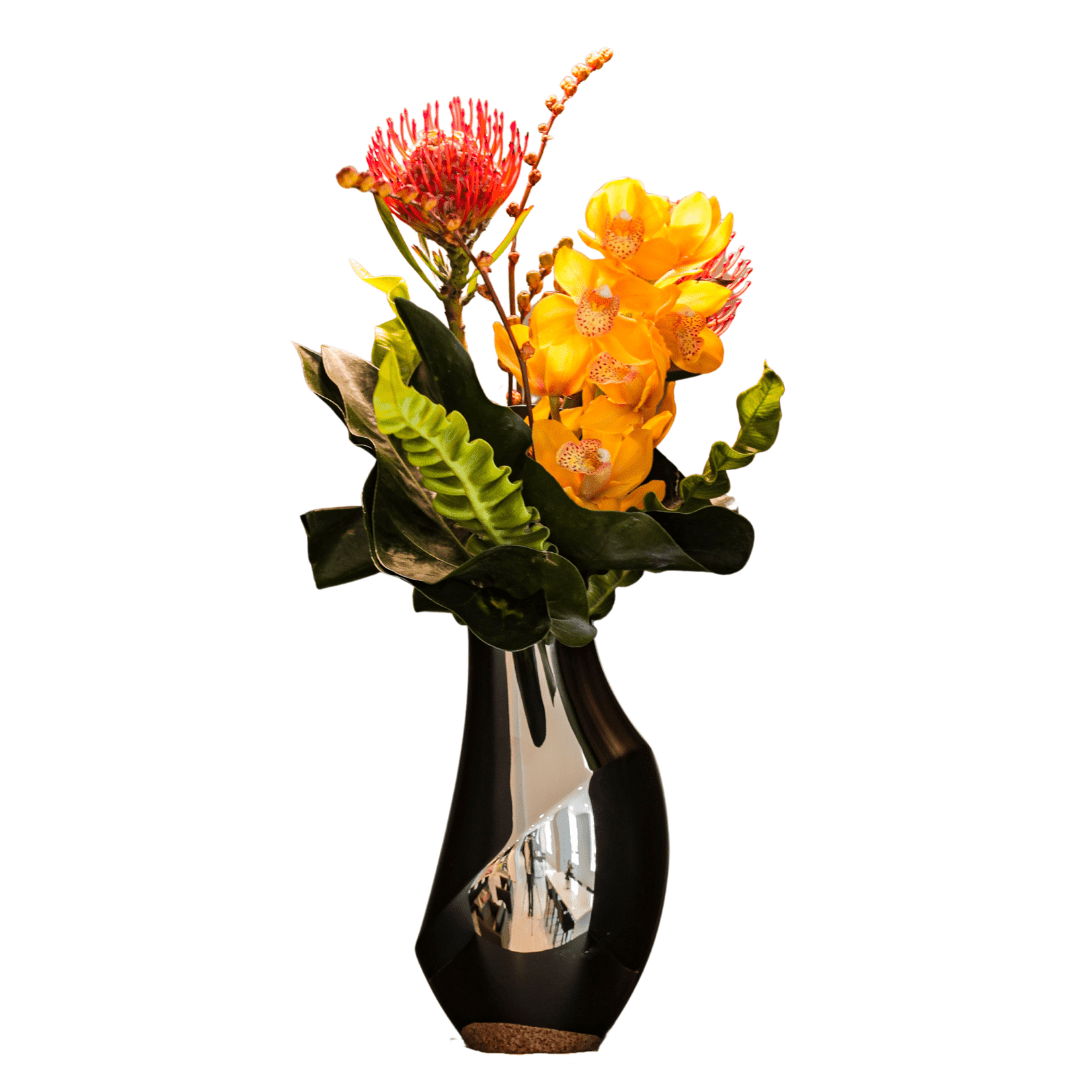 Small architectural floral arrangement in a modern metallic vase featuring Orchids and Protea