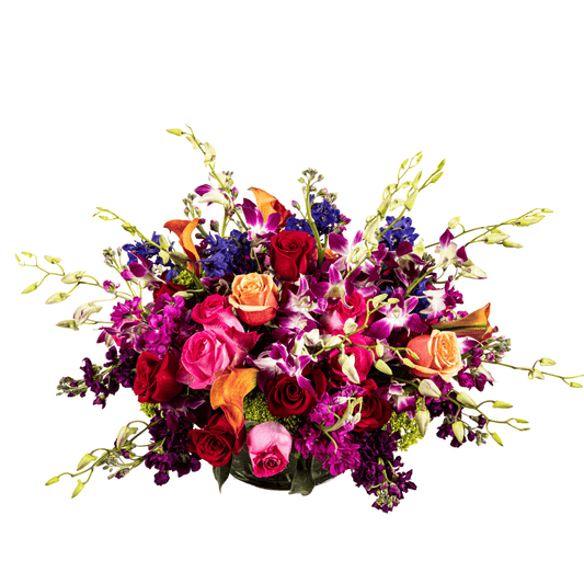 Large and low colorful floral arrangement featuring Orchids and Roses