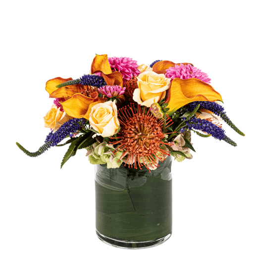 Floral arrangement featuring orange Calla Lilly, Protea and Roses 